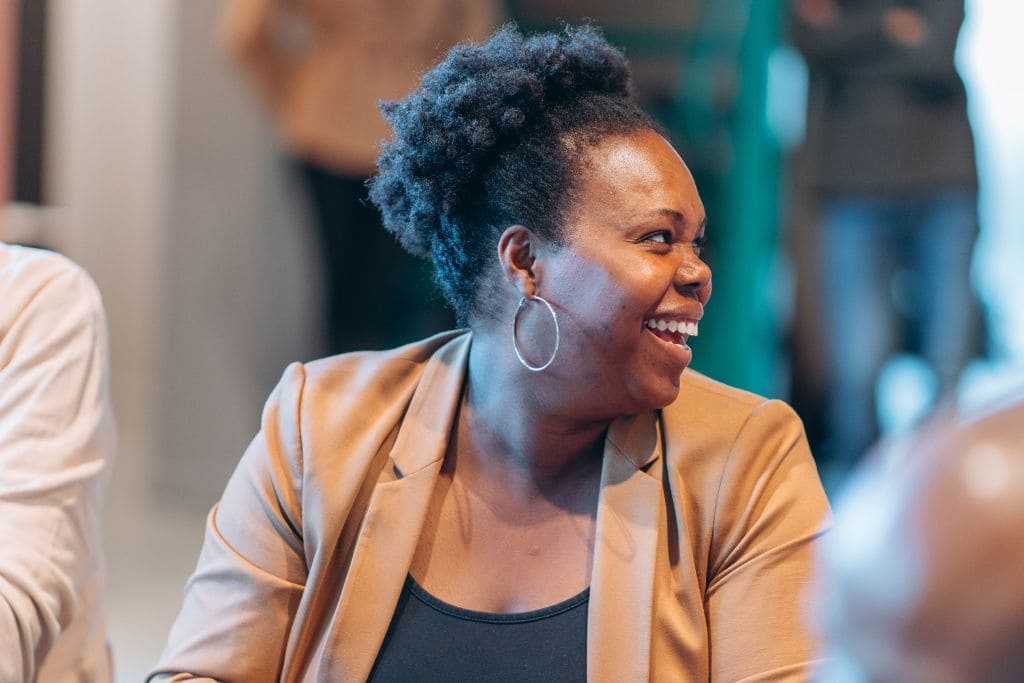 Vrouw glimlacht tijdens een groepstraining Overtuigen van Happy Good Talk. Vrouw glimlacht tijdens een groepstraining Overtuigen van Happy Good Talk.